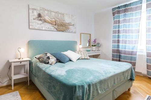 ein Schlafzimmer mit einem Bett mit einer blauen Decke darauf in der Unterkunft Apartment Rudolfsplatz in Wien