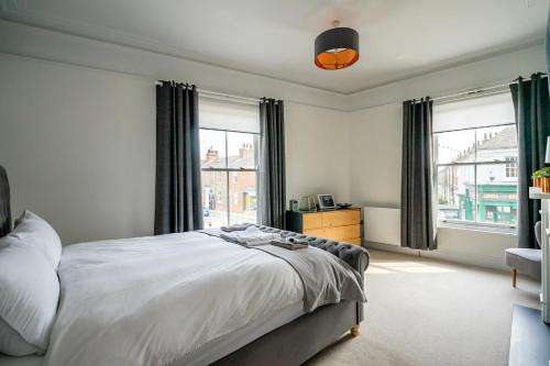 a bedroom with a bed and two windows at 123 Nunnery Lane in York