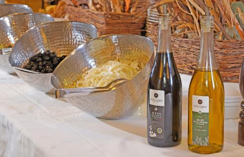two bottles of wine on a table with a bowl of food at Hotel Caravel in Limone sul Garda