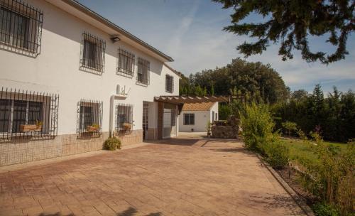 a large white house with a driveway at Casa Rural Rosa Blanca in Los Teatinos