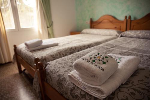 a bedroom with two beds with towels on them at Casa Rural Rosa Blanca in Los Teatinos