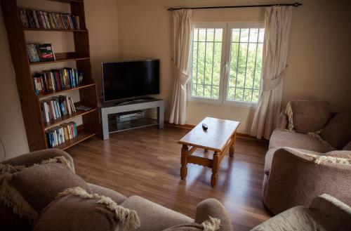a living room with two couches and a tv at Casa Rural Rosa Blanca in Los Teatinos