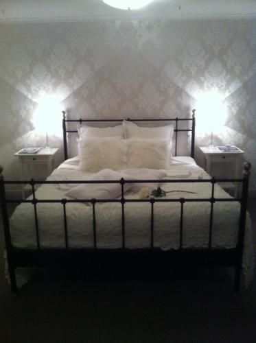 a bedroom with a bed with two lamps on it at Huskvarna Hotell & Vandrarhem in Huskvarna