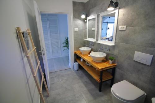 een badkamer met 2 wastafels en een spiegel bij Tramontana apartment - Cozy and charming close to sea in Opatija