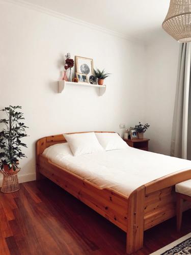 a bedroom with a wooden bed with white sheets at Apartamento en el autentico corazón de Mundaka in Mundaka