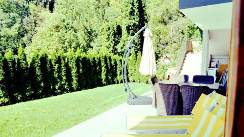 a patio with an umbrella and chairs and a lawn at Flamind Holiday Apartments mit Garten und Grill in Altenberg bei Linz