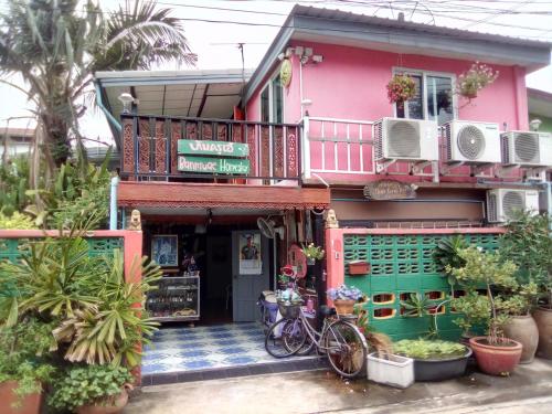 a pink house with bikes parked in front of it at Ban Kru Ae mixed dorm in Ban Don Muang