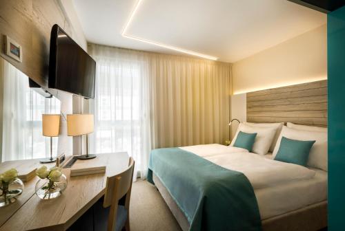 una camera d'albergo con letto e scrivania di Hotel Marina - Liburnia a Mošćenička Draga