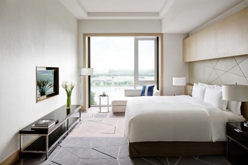 une chambre d'hôtel avec un lit et une grande fenêtre dans l'établissement Cordis, Beijing Capital Airport By Langham Hospitality Group, à Shunyi