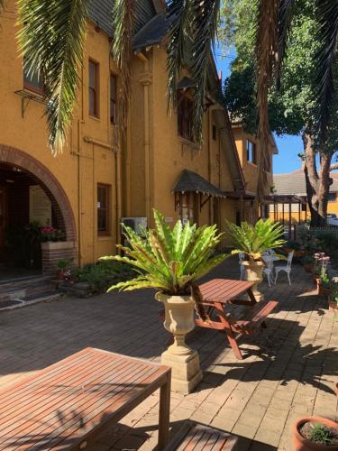 a patio with a table and a bench and a building at Burwood Bed and Breakfast in Sydney