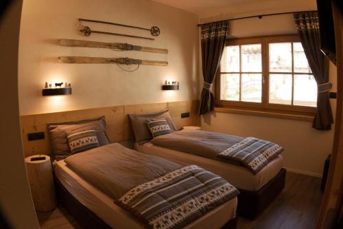 two beds sitting in a room with a window at Chalet Remì - Parè in Livigno
