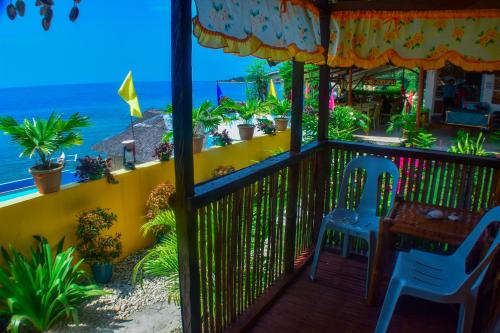 a balcony with a table and chairs and the ocean at MLK Bamboo Beachhouse in Alegria