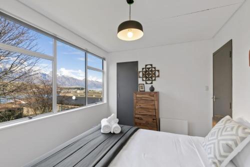 een slaapkamer met een bed en een groot raam bij Scenic Apartment 1 in Queenstown