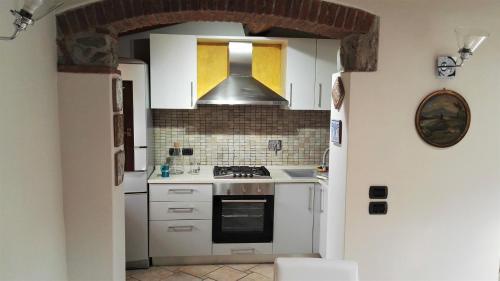 a kitchen with white cabinets and a stove top oven at Casa Giulia in Prato