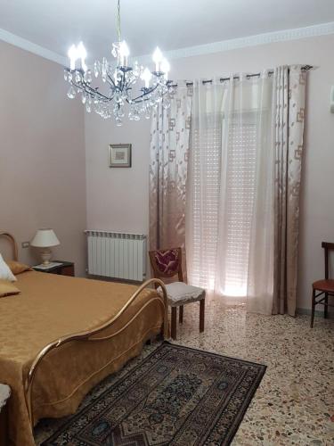 Schlafzimmer mit einem Bett und einem Kronleuchter in der Unterkunft Rosy home in Ribera