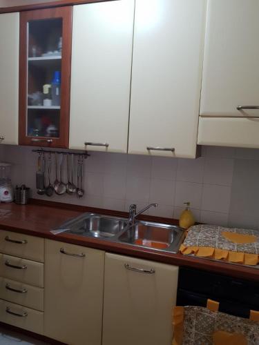 una cucina con lavello in acciaio inossidabile e armadietti bianchi di Rosy home a Ribera