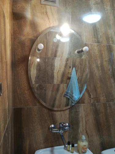 a bathroom with a round mirror and a sink at Apartamenty Kletówka in Krosno