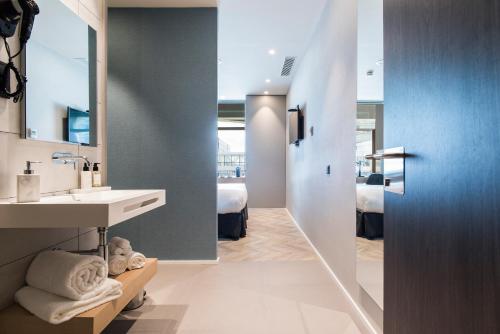 La salle de bains est pourvue d'un lavabo et d'un miroir. dans l'établissement Sleep&Fly, à El Prat de Llobregat