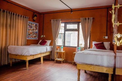 a bedroom with two beds and a window at Wander Thirst in Kathmandu