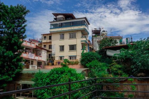a building on a hill with trees in front of it at Wander Thirst in Kathmandu