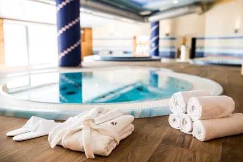 a bathroom with towels and a swimming pool at Amenity Hotel & Resort Lipno in Lipno nad Vltavou