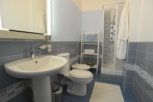 łazienka z białą umywalką i toaletą w obiekcie B&B Mare di Augusta La Finestra sul Porto w Auguście