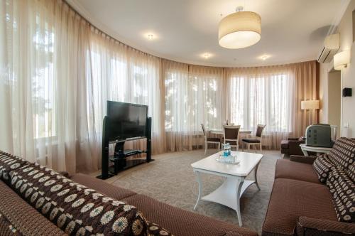 a living room with a couch and a tv and a table at Palace Del Mar in Odesa