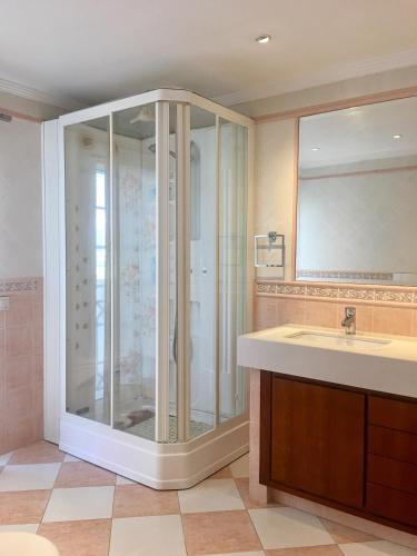 a bathroom with a glass shower and a sink at Casa das Figuras in Faro