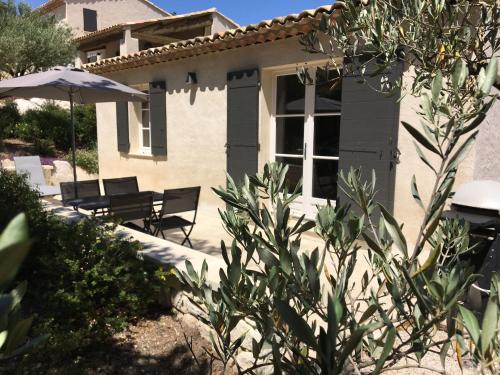 EyraguesにあるModern holiday cottage with swimming pool and close to beautiful Saint Remy de Provenceのパティオと傘付きの家