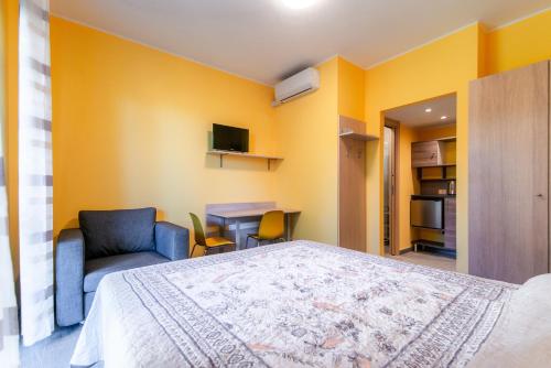 a bedroom with a bed and a chair and a table at Casa Livio - Rooms and studios in Como