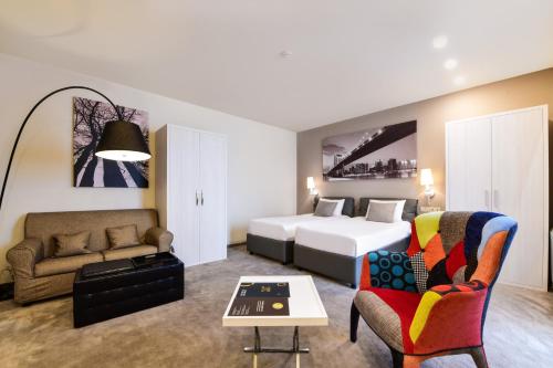 エレバンにあるOpera Suite Hotelのベッドとソファのあるホテルの部屋