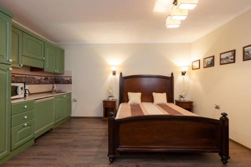 - une cuisine avec un lit dans une pièce dotée d'armoires vertes dans l'établissement Eric Central Studio, à Sibiu