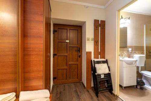 La salle de bains est pourvue d'une porte en bois et d'un lavabo. dans l'établissement Eric Central Studio, à Sibiu