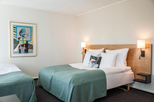 a hotel room with a large bed with two pillows at Hotel Koldingfjord in Kolding