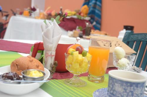 una mesa con un plato de fruta y un vaso de zumo de naranja en Hostal La Posada De Jose Carlos en Puerto Baquerizo Moreno