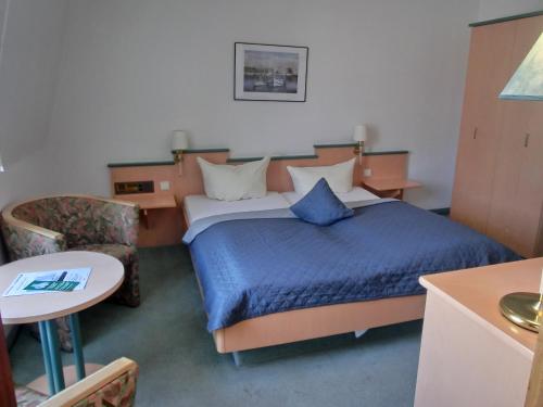 a hotel room with a bed and a chair at Hohwachter Hof in Hohwacht
