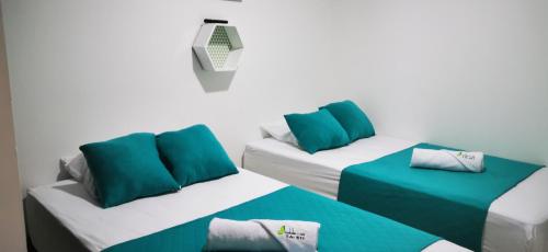 a room with two beds with green and white pillows at Guaduales del café 511 A en montenegro in Montenegro