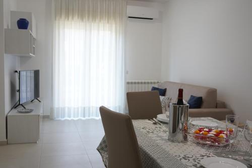 a dining room with a table with a bottle of wine at Casa Gisé in Aci Castello