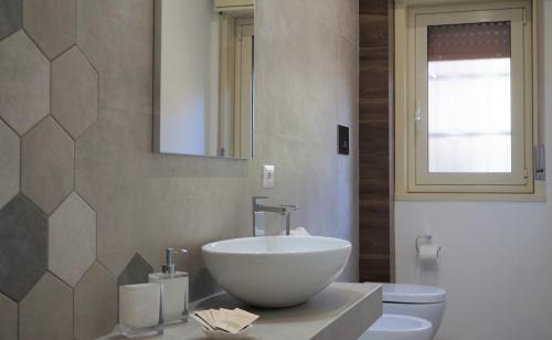 a bathroom with a bowl sink and a toilet at Casa Gisé in Aci Castello
