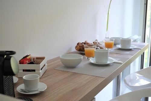 a table with cups and plates of food and orange juice at Casa Gisé in Aci Castello