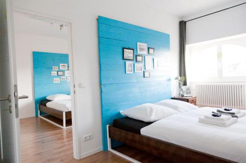 a bedroom with a blue headboard and a bed at Green Residence Boutique Lofts & Villa am Park in Offenbach