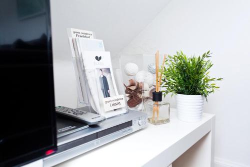 a table with a tv and some items on it at Green Residence Boutique Lofts & Villa am Park in Offenbach