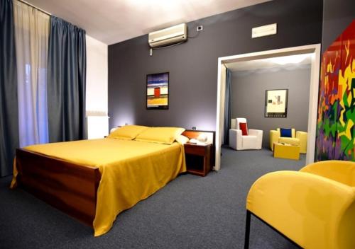 a bedroom with a yellow bed and yellow chairs at Il Cascinalenuovo in Asti