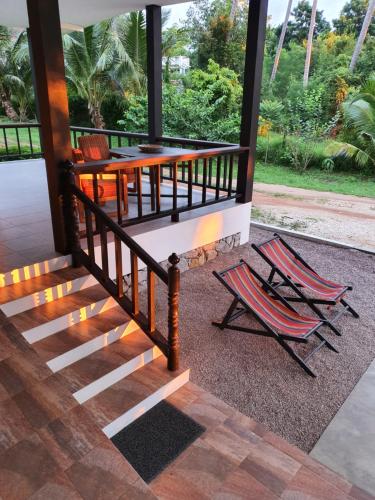 a porch with two chairs and a table at 155 SalaCoco in Ban Krut