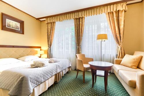 a hotel room with a bed and a table and a chair at Park Hotel in Szczecin