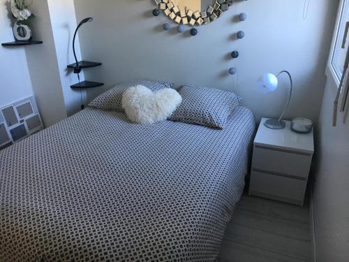 a bedroom with a bed with a teddy bear on it at Appartement T2 refait à neuf, piscine in Quiberon