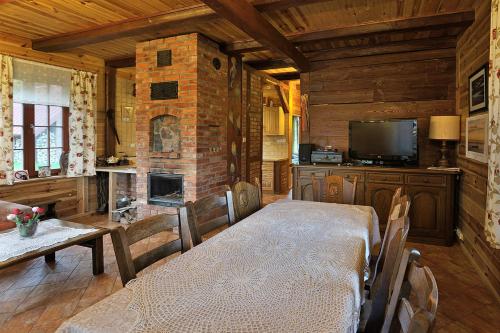 a dining room with a table and a fireplace at mazury-dom in Świętajno