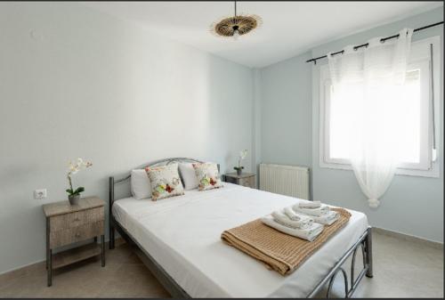 a white bedroom with a large bed with a window at Bright Spacious Two-Bedroom Apartment in Thessaloniki