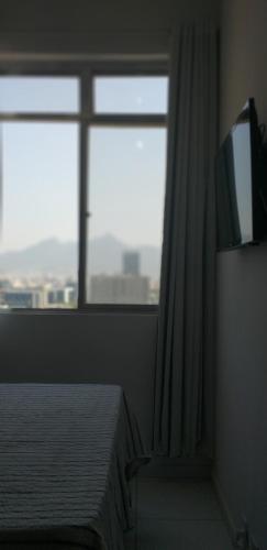 1 dormitorio con cama y ventana grande en Centro, Privado total, Metrô, rodoviária, Copacabana em 10 minutos, SmarTV en Río de Janeiro