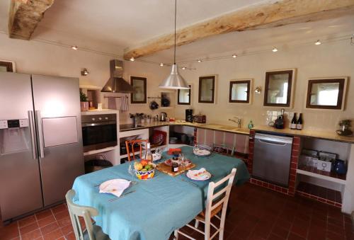 uma cozinha com uma mesa com uma toalha de mesa azul em DOMAINE de MAS CARON Gîte 4* au pied du Ventoux en Provence em Caromb
